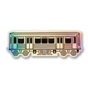 May include: A black and white line drawing of a subway train on a holographic sticker. The sticker has a rainbow iridescent finish. The text "©2018 TRANSIT TEES, INC." is printed on the sticker.