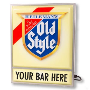 May include: Rectangular illuminated sign with a silver frame. The sign features the text "HEILEMAN'S Old Style" in a shield design with red and blue accents. The bottom of the sign reads "YOUR BAR HERE".