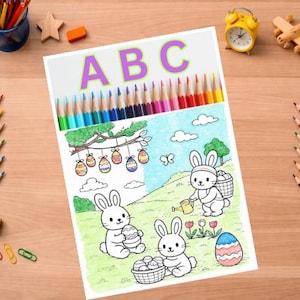 Könnte beinhalten: Eine Malvorlage mit den Buchstaben "ABC" in Lila, die Ostereier, Hasen und einen Baum zeigt. Oben befinden sich Buntstifte. Weitere Buntstifte, ein Spitzer und Büroklammern liegen auf der Holzoberfläche.