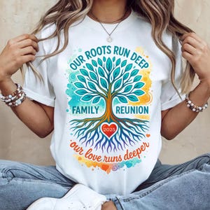 May include: White t-shirt featuring a tree graphic with the text "OUR ROOTS RUN DEEP FAMILY REUNION 2025 our love runs deeper". The design is in a circular arrangement around the tree.