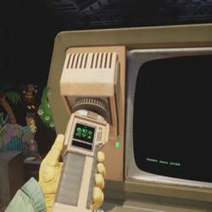 May include: A person holding a beige and gray handheld device with a small screen displaying green symbols. The device is pointed towards a vintage computer monitor with a blank black screen. The monitor is housed in a beige casing.