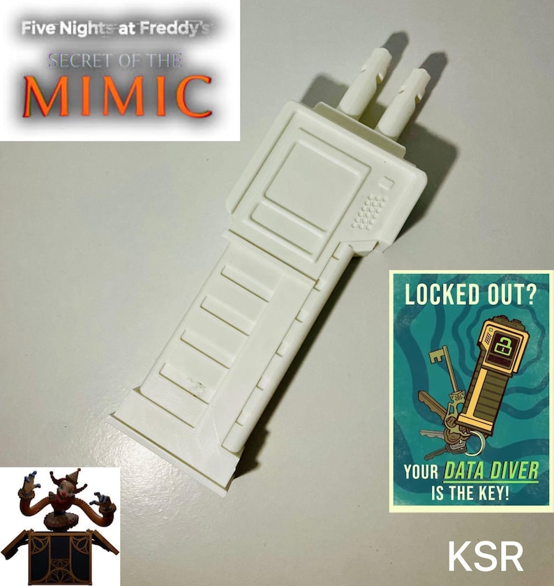 May include: A white plastic prop resembling a device, possibly a game controller or tool, with two protruding cylinders. The image includes text from "Five Nights at Freddy's: Secret of the Mimic" and a poster that says "Locked Out? Your Data Diver is the Key!"