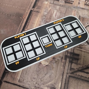 Può includere: Un tabellone di gioco in bianco e nero con le scritte "PLAYER 1", "PLAYER 2", "TURN", "VP" e "CP". Il tabellone ha diversi spazi quadrati per i pezzi del gioco.