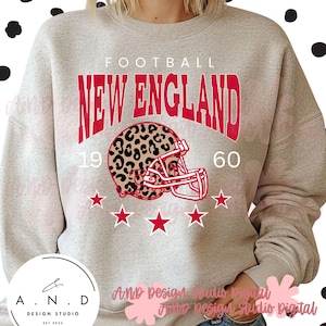 Könnte beinhalten: Hellgraues Sweatshirt mit rotem und leopardenmuster Footballhelm-Grafik. Der Text "FOOTBALL NEW ENGLAND 1960" ist über dem Helm aufgedruckt. Fünf rote Sterne befinden sich darunter.