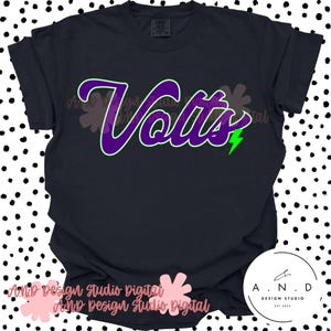 以下が含まれることがあります： 紫色の文字「Volts」と緑色の縁取りが施された黒いTシャツ。単語の横には緑色の稲妻のグラフィックがあります。Tシャツはクルーネックと半袖です。