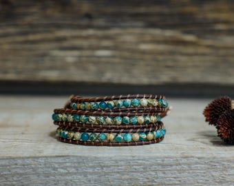 May include: A multi-layered bracelet with brown leather and turquoise and white patterned beads.