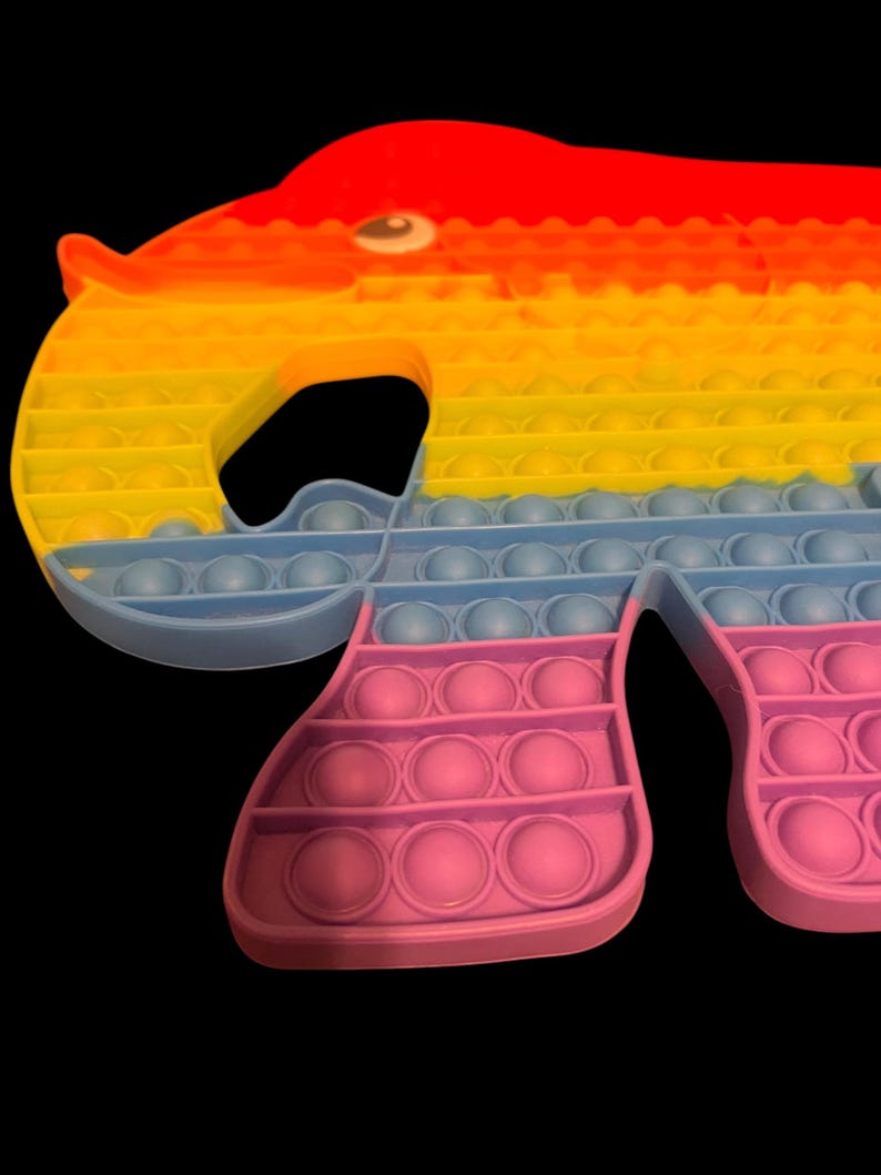 May include: A colorful elephant-shaped pop-it toy. The toy features a gradient of colors, starting with red at the top, transitioning to yellow and orange, then blue, and finally pink at the bottom. The toy has multiple bubble-like circles.