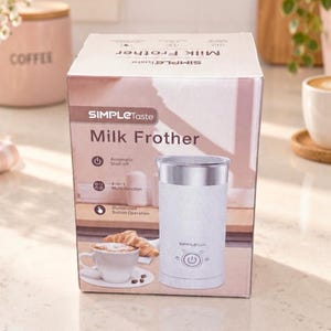 Puede incluir: Una caja de cartón blanca para un espumador de leche SimpleTaste. La caja muestra el texto Milk Frother, Automatic Shut-off, 4-in-1 Multi-function e Illuminated Button Operation, junto a una imagen del espumador y una taza de café.