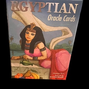 May include: Box of "EGYPTIAN Oracle Cards" featuring an illustration of an Egyptian woman in pink and red robes. The box has a blue background with the title in brown and white lettering. Artwork by Severino Baraldi.