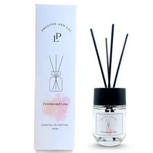 May include: A clear glass essential oil diffuser with black reeds and a black cap. The product is labeled "Freesia and Lilac" and includes the text "PRESTON AND LEE" and "ESSENTIAL OIL DIFFUSER 100ML" on the packaging.