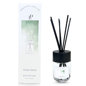 May include: A clear glass reed diffuser with black reeds and a black cap. The product is labeled "White Birch" and comes with a matching box. The box features the brand name "Preston and Lee" and a graphic of the diffuser.