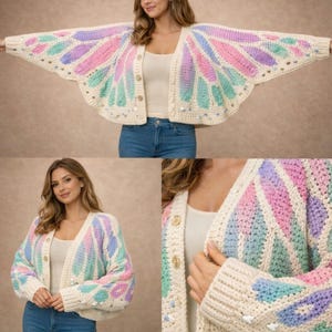 May include: Cream-coloured, open-front cardigan with a butterfly wing design in pastel colours. The crochet sweater features button closures and is adorned with small, decorative embellishments. The sleeves are long and the overall style is relaxed.