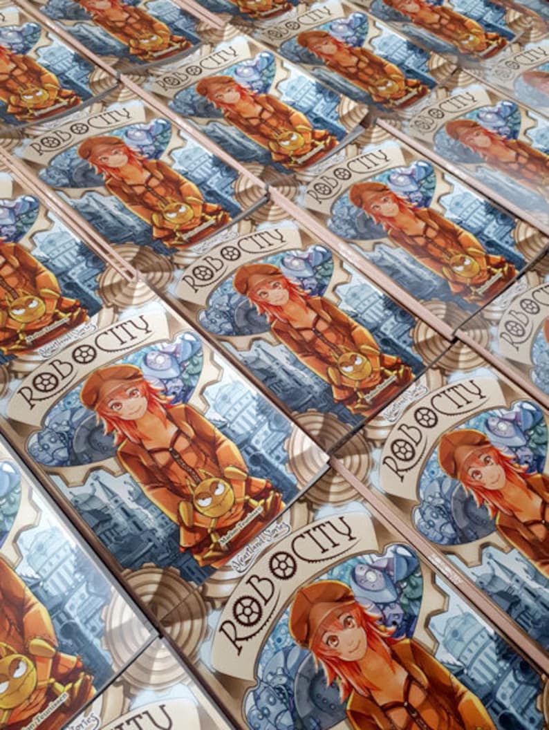 May include: Several copies of a card game box with a steampunk illustration. The artwork shows a red-haired character in a brown outfit, holding a small robot. The game title "ROBOCITY" is displayed in a banner.