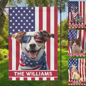 May include: A patriotic garden flag featuring a smiling dog wearing sunglasses with an American flag design and a matching scarf. The flag has the text "THE WILLIAMS" at the bottom. Additional flags with pets are also visible.