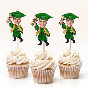 May include: Three graduation themed cupcake toppers with a cartoon image of a person wearing a graduation cap and gown. The toppers say "Daniel" and "Class of 2023".