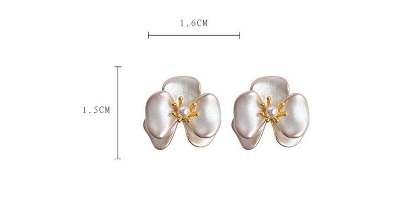 Pode incluir: Um par de brincos em forma de flor com p&eacute;talas brancas e um estame central dourado com uma pequena p&eacute;rola branca. Os brincos medem 1,6 cm de largura e 1,5 cm de altura, conforme indicado pelas linhas de medi&ccedil;&atilde;o na imagem.