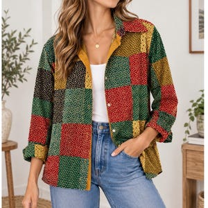May include: A long-sleeve button-down shirt featuring a patchwork design of square panels in red, green, yellow, and black, each decorated with a small white floral print. The shirt has a solid mustard yellow inner placket and a classic collar.
