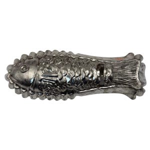 May include: A silver-toned metal fish-shaped mold featuring detailed embossed scales, fins, and a defined eye. The mold has a scalloped edge along the perimeter and a small metal loop attached to the top surface near the tail section for hanging.