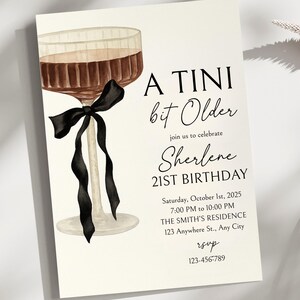 Puede incluir: Una tarjeta de invitaci&oacute;n color crema con una ilustraci&oacute;n en acuarela de una copa de c&oacute;ctel con un lazo negro. El texto dice "A Tini bit Older" y anuncia el 21 cumplea&ntilde;os de Sherlene el 1 de octubre de 2025.