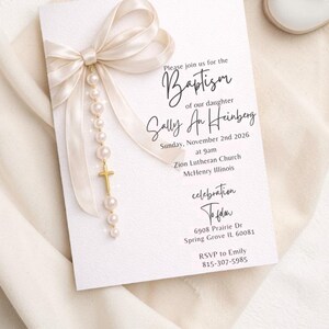 Puede incluir: Una tarjeta de invitaci&oacute;n de bautizo con un lazo color crema y una escritura elegante. La tarjeta incluye el texto "Please join us for the Baptism of our daughter Sally An Heinberg" y los detalles del evento. Una cruz dorada y perlas cuelgan del lazo.