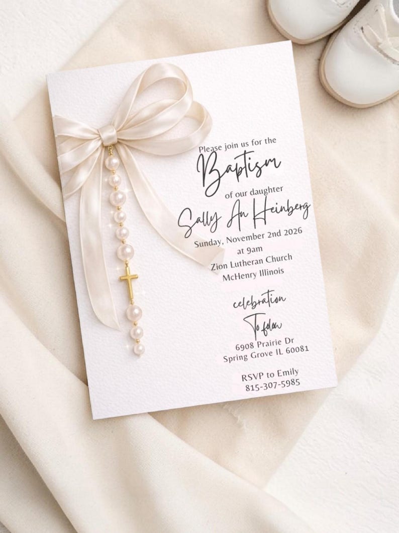 Puede incluir: Una tarjeta de invitaci&oacute;n de bautizo con un lazo color crema y una escritura elegante. La tarjeta incluye el texto "Please join us for the Baptism of our daughter Sally An Heinberg" y los detalles del evento. Una cruz dorada y perlas cuelgan del lazo.