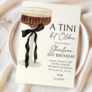 Puede incluir: Una tarjeta de invitaci&oacute;n color crema con una ilustraci&oacute;n de acuarela de una copa de c&oacute;ctel con un lazo negro. El texto dice "A TINI bit Older" y anuncia el 21 cumplea&ntilde;os de Sherlene el 1 de octubre de 2025.