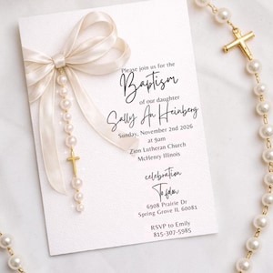 Puede incluir: Una tarjeta de invitaci&oacute;n de bautizo blanca con una escritura elegante y un lazo de cinta color crema. La tarjeta est&aacute; adornada con un collar de perlas y una cruz dorada. El texto en la tarjeta dice "Bautizo de nuestra hija Sally An Heinberg".