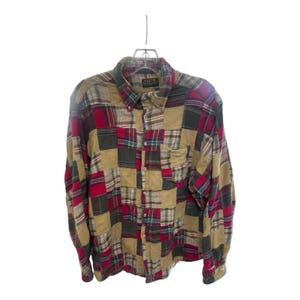 Può includere: Camicia patchwork a maniche lunghe con bottoni. La camicia presenta un mix di quadrati di tessuto a quadri e tinta unita in rosso, verde, beige e blu navy. Ha un colletto button-down e una tasca sul petto.