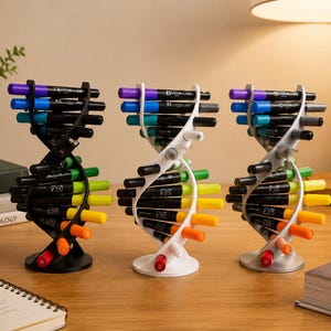 Puede incluir: Tres organizadores de marcadores con forma de ADN colocados verticalmente. Un organizador es negro, otro blanco y otro plateado. Cada estructura sostiene varios marcadores de colores en espiral, con tapas visibles en tonos morado, azul, verde, amarillo, naranja y rojo.