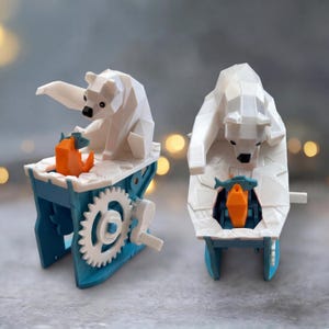 May include: Two white geometric polar bear sculptures with black noses and eyes. One bear sits on a blue and white structure with a gear and a crank. An orange fish is in front of the bear. The other bear is on a similar structure.