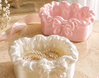 Zijden strik sieraden organizer met ruches, een speelse opbergoplossing voor de kaptafel in de slaapkamer.