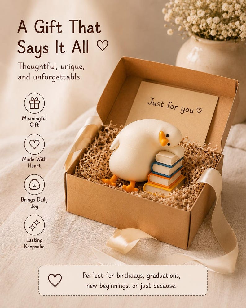 Puede incluir: Una caja de regalo de cart&oacute;n marr&oacute;n rellena de papel triturado, que contiene una figura de pato blanco descansando sobre una pila de cuatro libros coloridos. Una tarjeta interior dice Just for you. La tapa muestra el texto A Gift That Says It All.