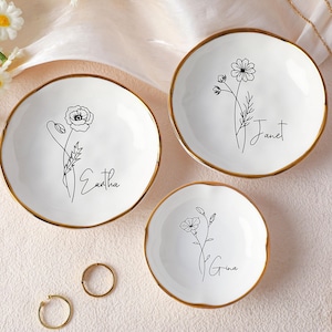 Puede incluir: Un juego de tres tazas de cerámica con un acabado mate moteado. Las tazas son de color crema, gris claro y gris oscuro. Cada taza tiene un diseño simple y minimalista, adecuado para café o té.