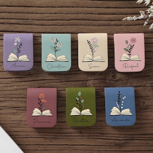 Puede incluir: Siete marcap&aacute;ginas magn&eacute;ticos coloridos con dise&ntilde;os florales y nombres. Cada marcap&aacute;ginas presenta un color diferente, incluyendo morado, verde azulado, beige, rosa, granate, verde y azul. Los nombres Miriam, Christine, Susie, Rafael, Florence, Bertha y Amanda est&aacute;n escritos.