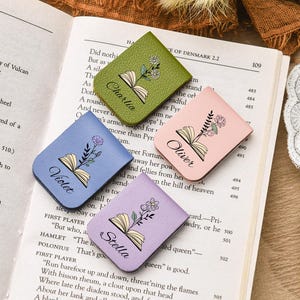 Puede incluir: Cuatro marcap&aacute;ginas de cuero de colores con dise&ntilde;os florales y nombres personalizados: Charli, Oliver, Violet y Stella. Los marcap&aacute;ginas est&aacute;n sobre un libro abierto, p&aacute;gina 109.