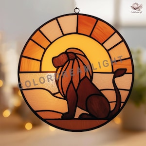 May include: Round stained glass panel featuring a lion silhouette against a sunset backdrop. The design incorporates shades of orange, yellow, and brown. The text "COLOR DREAM LIGHT" is visible. Includes a hanging loop.