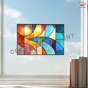 May include: A rectangular stained glass window with a black frame. The design features abstract shapes in shades of red, orange, yellow, blue, and purple. The text "COLOR DREAM LIGHT" is visible at the bottom left.