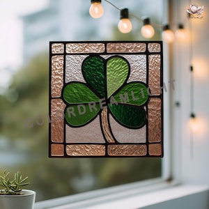 May include: Stained glass window panel featuring a green shamrock design. The shamrock has three heart-shaped leaves in varying shades of green. The panel is framed with a textured, light brown and clear glass border, and a black outline.