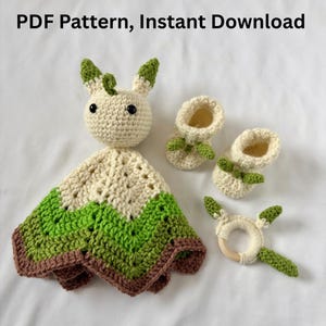 May include: A crochet baby set including a bunny lovey, two booties, and a wooden ring teether. The set is primarily cream, green, and brown, with the text "PDF Pattern, Instant Download" at the top.