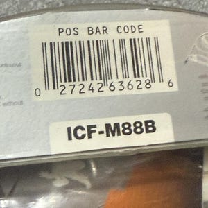 Pu&ograve; includere: Primo piano di un'etichetta di prodotto con un codice a barre e la scritta "POS BAR CODE". Sotto il codice a barre c'&egrave; il numero "0 27242 63628 6". L'etichetta mostra anche la scritta "ICF-M88B".