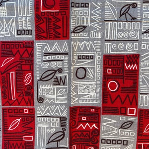 May include: A grey and red fabric with a geometric pattern. The pattern is made up of circles, squares, and triangles. The fabric is textured and has a slightly rough feel.