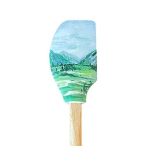 May include: A green and blue landscape painted on a silicone spatula with a wooden handle. The handle is labeled "John Boos."