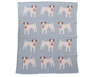 Può includere: Una coperta di maglia blu chiaro con un motivo ripetuto di Jack Russell terrier bianchi che indossano collari rossi. I cani sono rivolti in avanti con la lingua di fuori.
