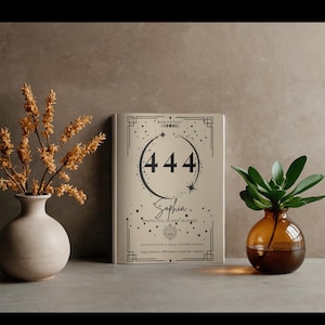 May include: A beige journal with the number 444, the name Sophia, and the text Protected, Guided, Aligned, Manifestation & Angel Number Journal, Daily Guidance, Affirmations, Gratitude, Intention printed on the front cover in black ink.