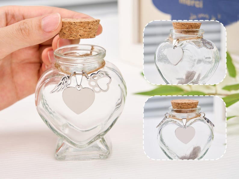 Peut inclure: Un bocal en verre transparent en forme de c&oelig;ur avec un bouchon en li&egrave;ge. Le bocal est orn&eacute; d'un charm argent&eacute; en forme de c&oelig;ur, d'une empreinte de patte et d'une aile. Con&ccedil;u pour contenir des souvenirs.