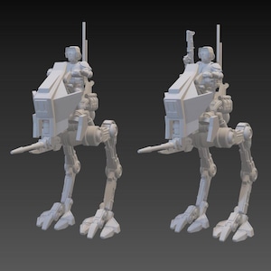 Puede incluir: Dos modelos idénticos, impresos en 3D, de color gris claro, de un vehículo caminante con una figura sentada. El caminante tiene una cabina, un cañón largo y patas articuladas. La figura lleva un casco y sostiene un arma.