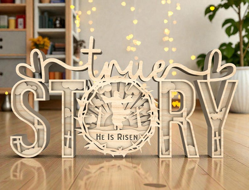 May include: A wooden sign that spells out "true STORY" in a layered design. The letter "O" features a circular design with a figure and the text "He Is Risen". The sign is light brown and sits on a wooden surface.