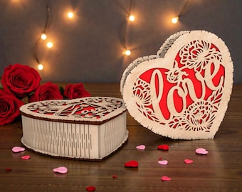 May include: Two heart-shaped wooden boxes with intricate floral cutouts. One box is open, revealing a red interior and the word "Love". Red roses and scattered heart-shaped confetti add to the romantic theme.