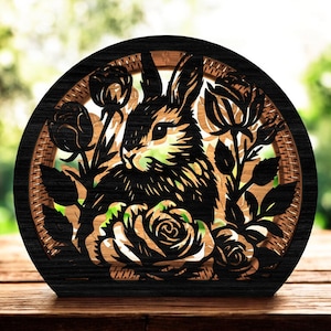 May include: A wooden, semi-circular decorative piece featuring a laser-cut design of a rabbit surrounded by roses. The rabbit is in profile, with intricate details in black and brown. The roses are also black, set against a light brown background.