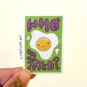 May include: A green sticker with a purple cartoon egg with a face and the text "Who's Fretted?" in purple.